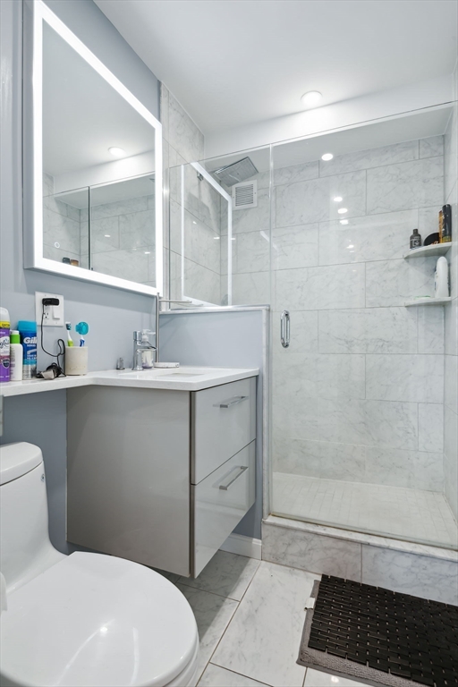 85 East India Row, Unit 16H Boston, MA 02110 - Photo 16 of 20 a bathroom with a sink toilet and shower