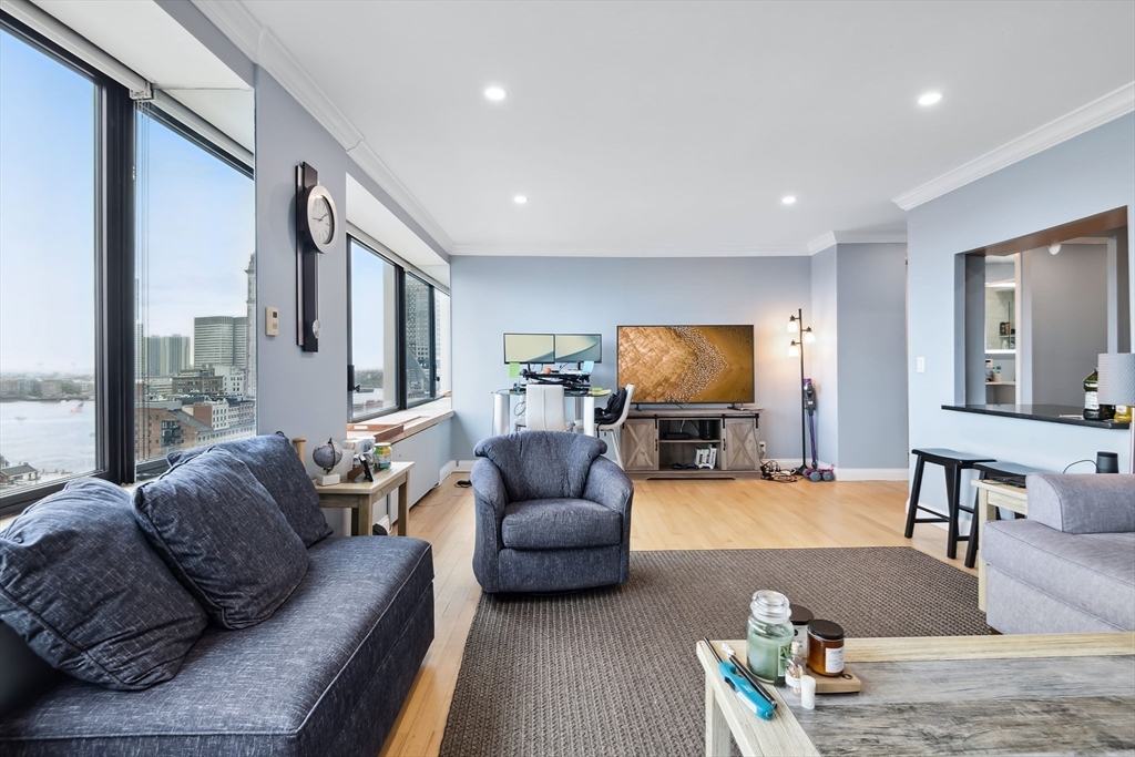 85 East India Row, Unit 16H Boston, MA 02110 - Photo 3 of 20 a living room with furniture and a flat screen tv