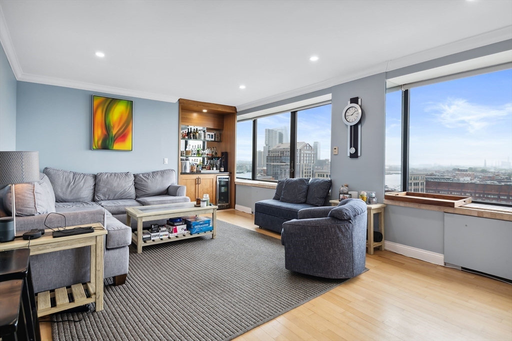 85 East India Row, Unit 16H Boston, MA 02110 - Photo 5 of 20 a living room with furniture and a floor to ceiling window