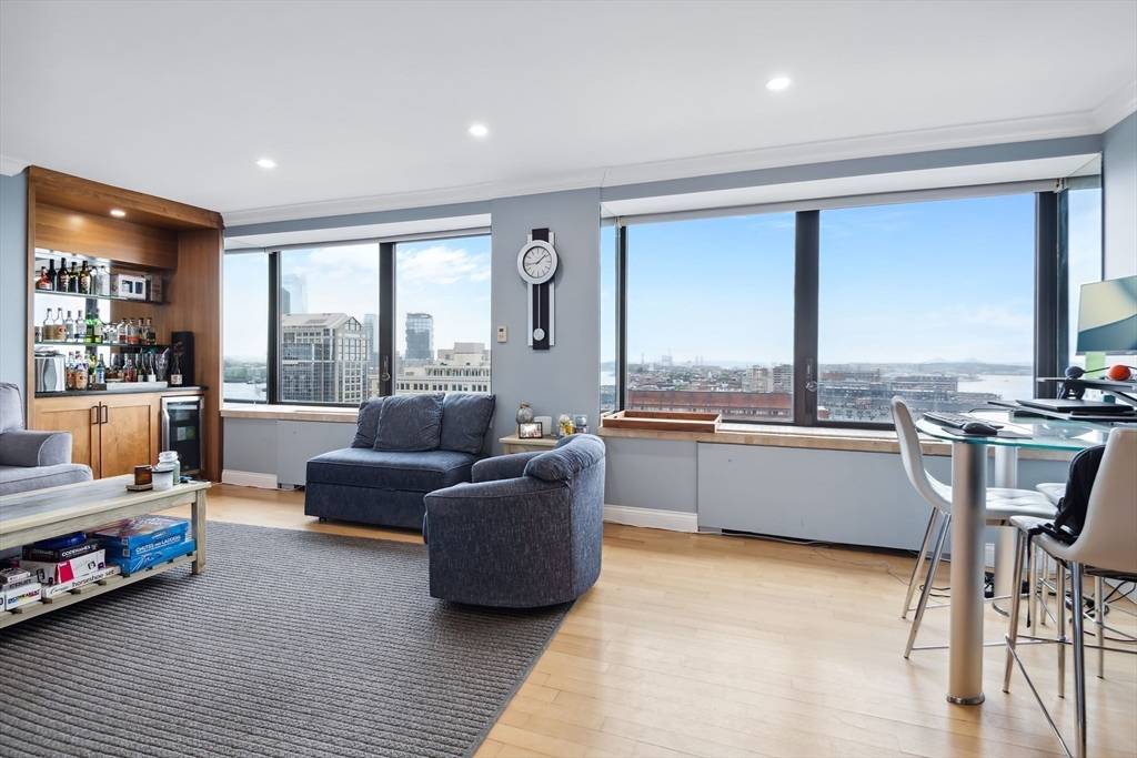 85 East India Row, Unit 16H Boston, MA 02110 - Photo 7 of 20 a large living room with a large window and furniture