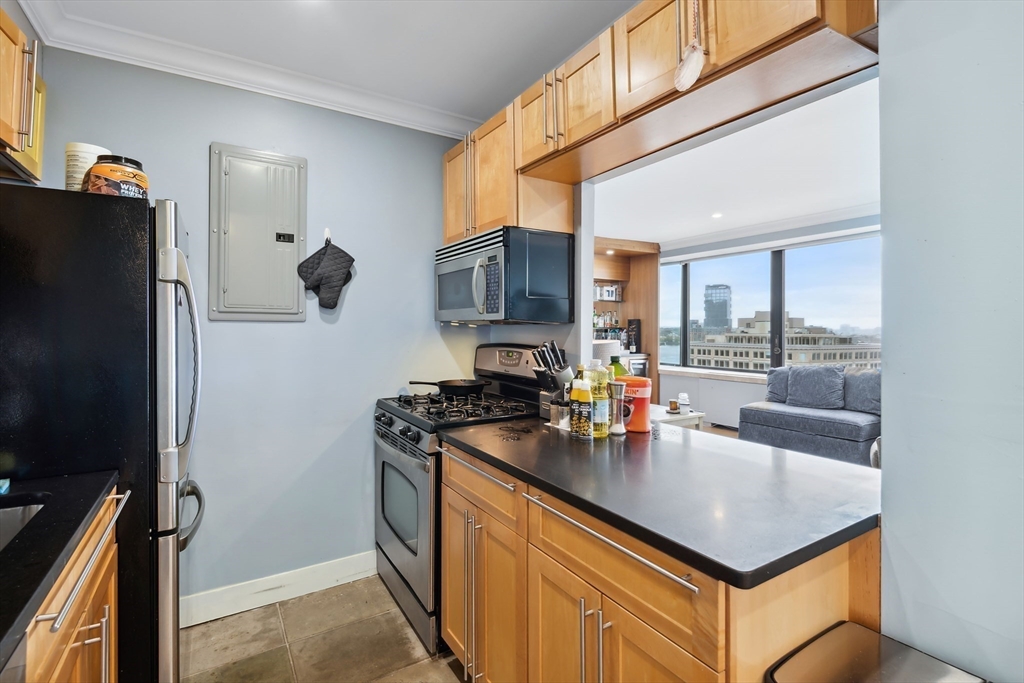 85 East India Row, Unit 16H Boston, MA 02110 - Photo 8 of 20 a kitchen with stainless steel appliances granite countertop a sink stove and refrigerator