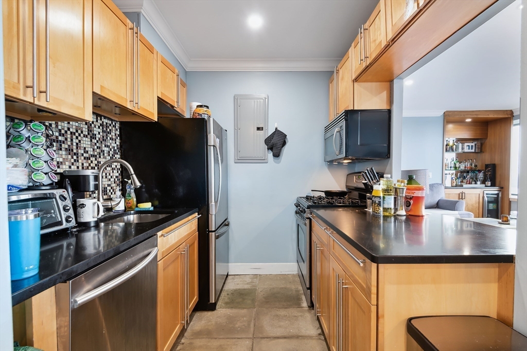 85 East India Row, Unit 16H Boston, MA 02110 - Photo 9 of 20 a kitchen with stainless steel appliances granite countertop a sink stove and refrigerator