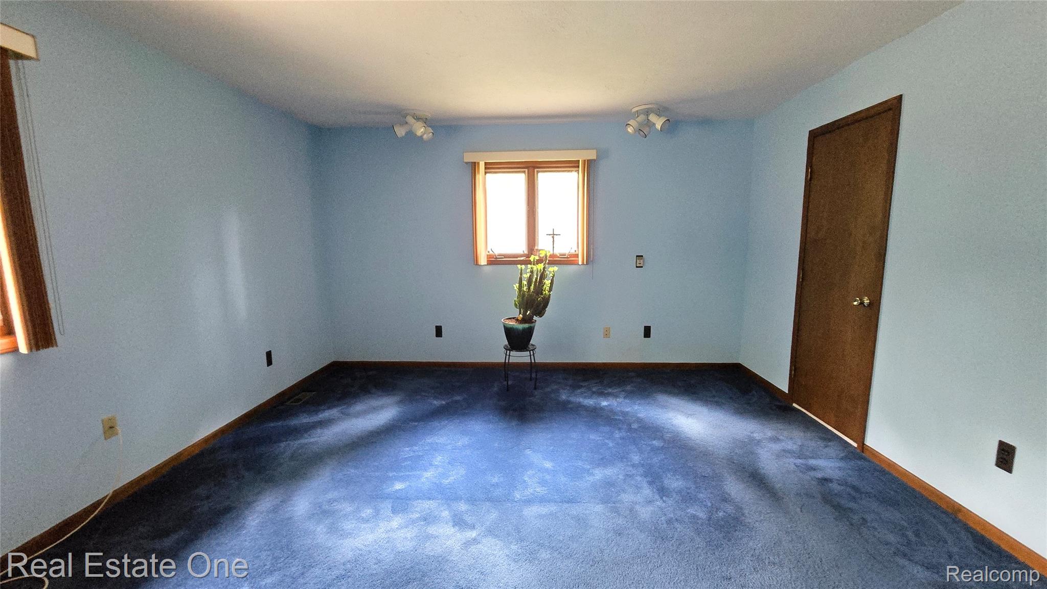 8950 Wise Road Commerce Township, MI 48382 - Photo 23 of 39 Spacious room featuring light blue walls, dark blue carpeting, and wood-trim windows