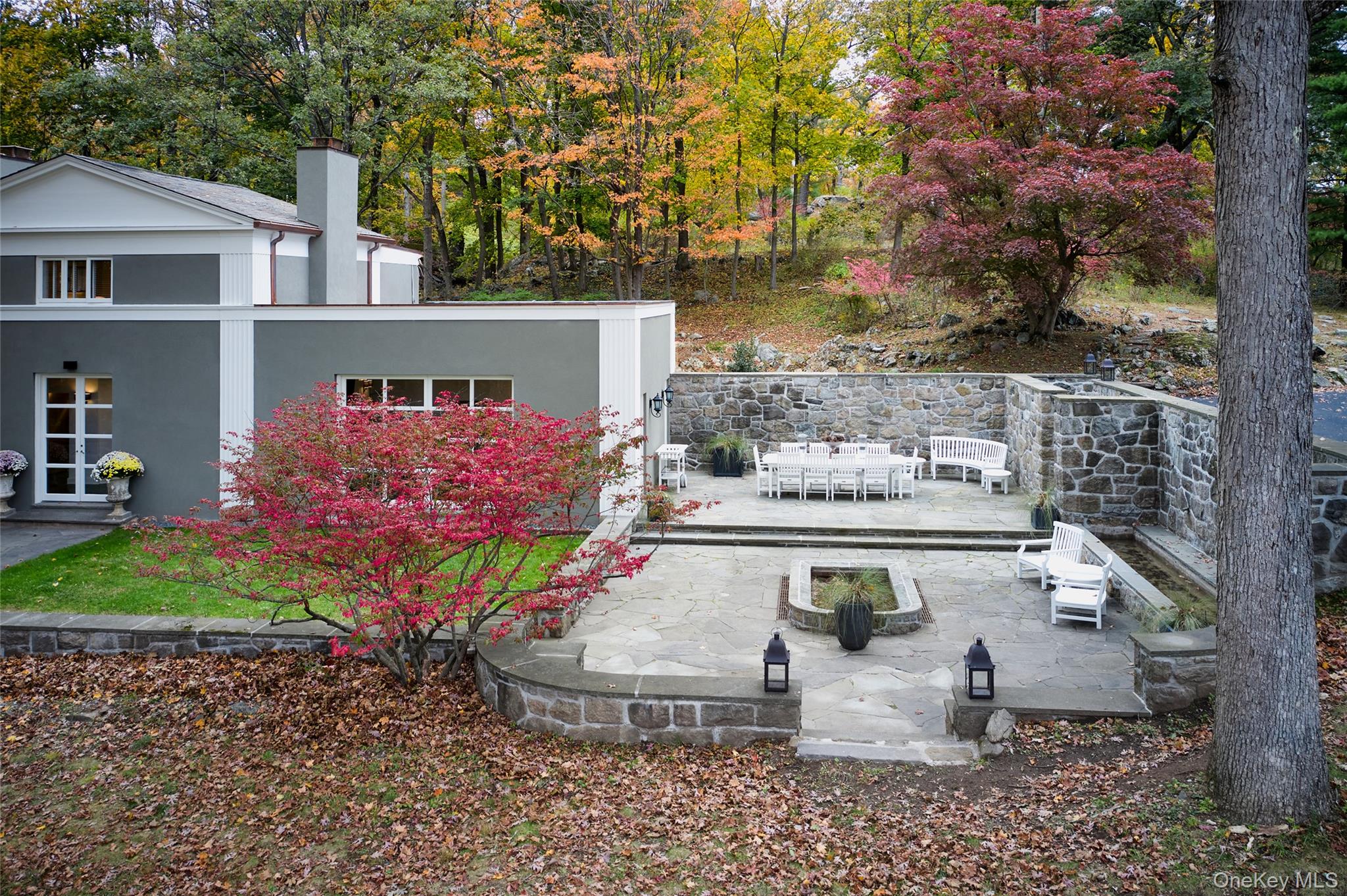 72 Lookout Road Tuxedo Park, NY 10987 - Photo 9 of 49 a view of a patio with couches table and chairs potted plants and large tree