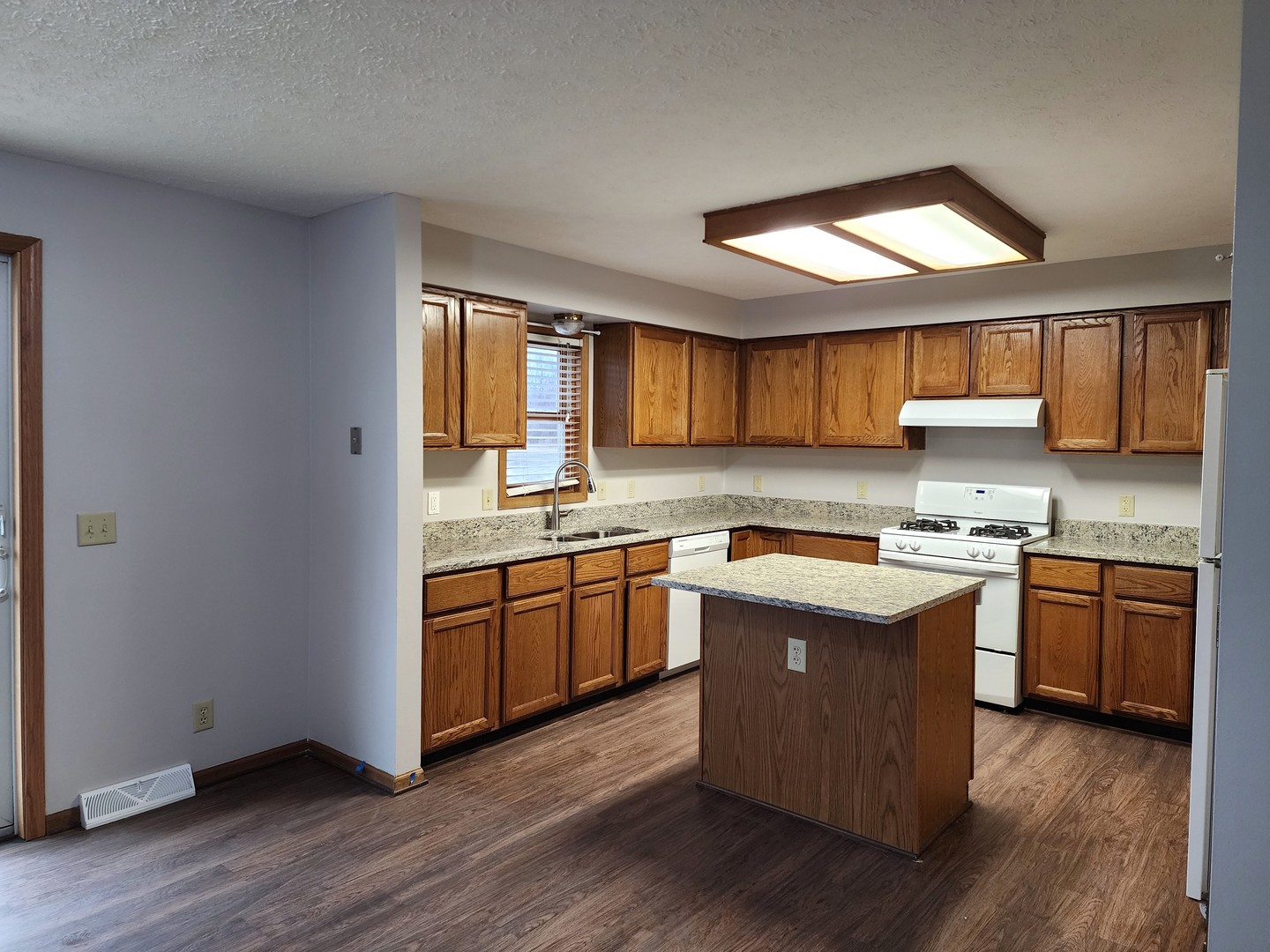 240 Mitchell Court Braidwood, IL 60408 - Photo 5 of 18 a kitchen with granite countertop wooden floors a sink and wooden cabinets