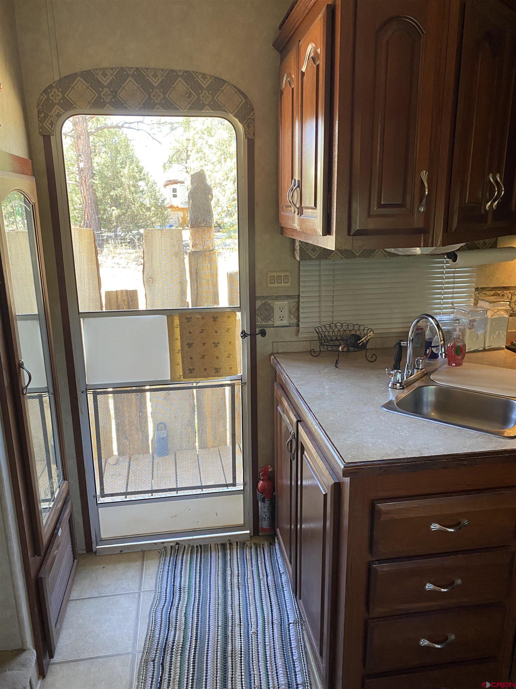 2444 Crooked Road Pagosa Springs, CO 81147 - Photo 15 of 22 a kitchen with a sink a window and cabinets