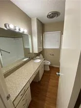 a bathroom with a granite countertop sink a toilet and a mirror