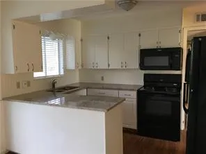 a kitchen with stainless steel appliances granite countertop a sink stove and microwave