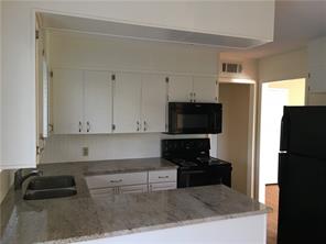 1400 Fairground Street, Unit C Taylor, TX 76574 - Photo 4 of 12 a kitchen with granite countertop a refrigerator and a stove top oven