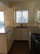a kitchen with a sink stove and cabinets