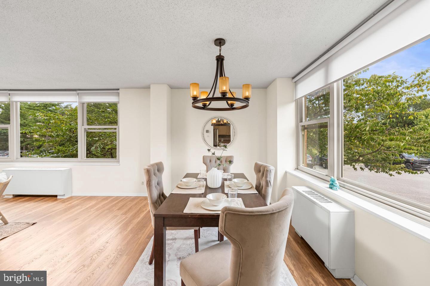 4401 Roland Avenue, Unit 115 Baltimore, MD 21210 - Photo 5 of 25 a dining room with furniture a chandelier and wooden floor