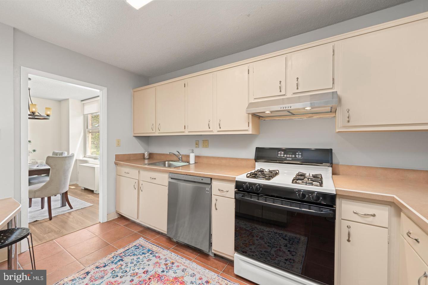 4401 Roland Avenue, Unit 115 Baltimore, MD 21210 - Photo 7 of 25 a kitchen with stainless steel appliances granite countertop a stove a sink and a refrigerator
