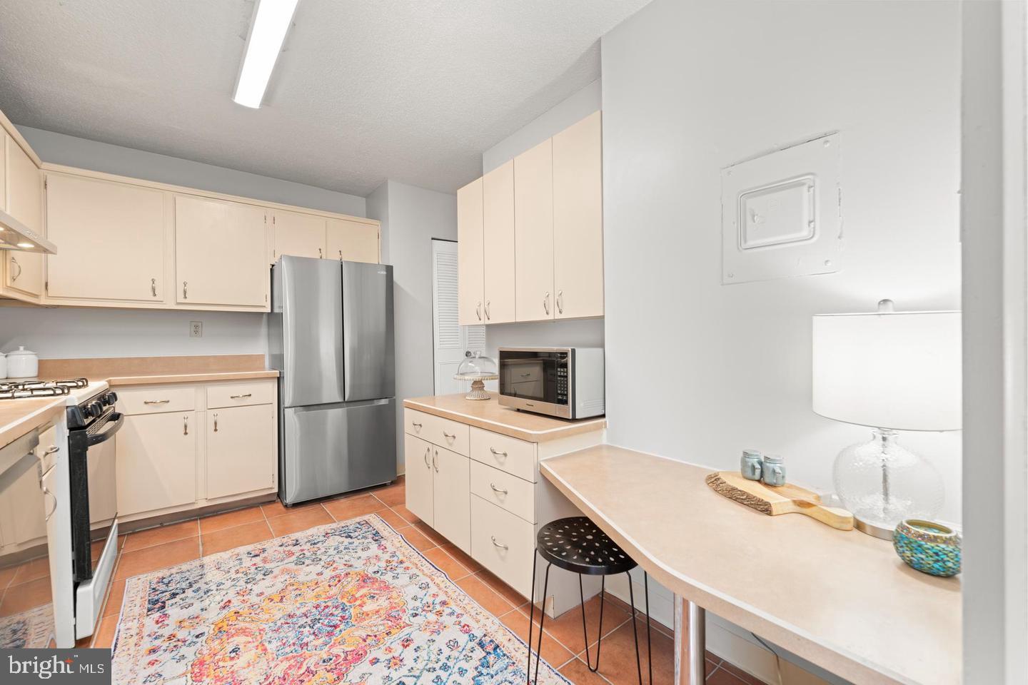4401 Roland Avenue, Unit 115 Baltimore, MD 21210 - Photo 9 of 25 a kitchen with a refrigerator sink and stove