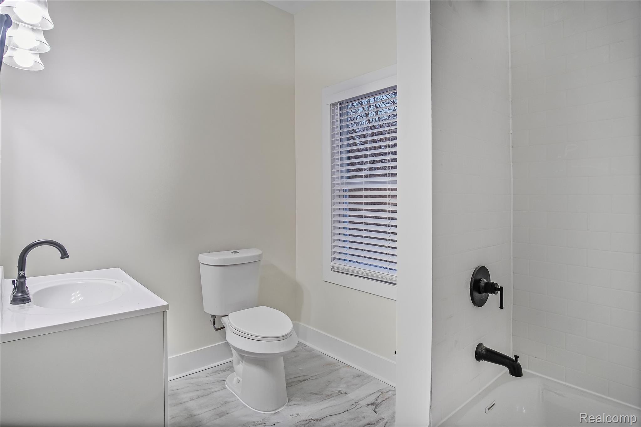 427 Melbourne Street Detroit, MI 48202 - Photo 8 of 29 Bathroom with vanity, light marble finish flooring, and shower / bathtub combination