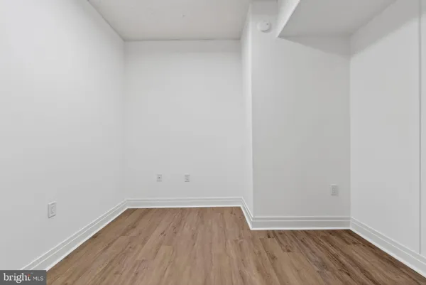 a view of a room with wooden floor and white walls