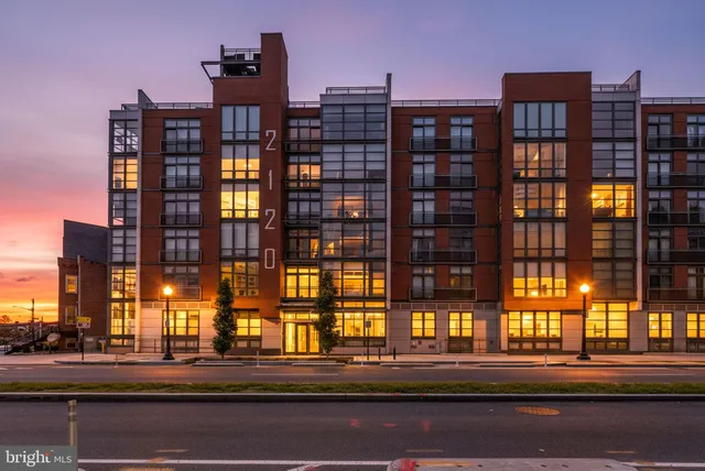 a kitchen with stainless steel appliances granite countertop a stove top oven a sink dishwasher a refrigerator and white cabinets with wooden floor