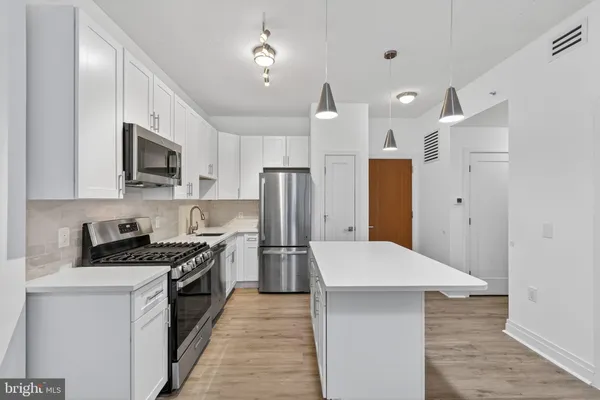 a kitchen with stainless steel appliances a refrigerator sink and stove