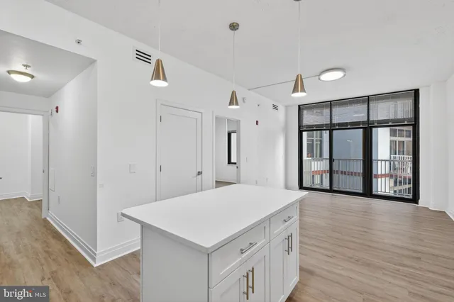 a kitchen with a sink dishwasher a stove and a microwave oven with white cabinets