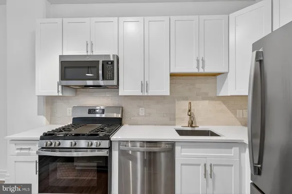 a kitchen with stainless steel appliances a stove a microwave and cabinets