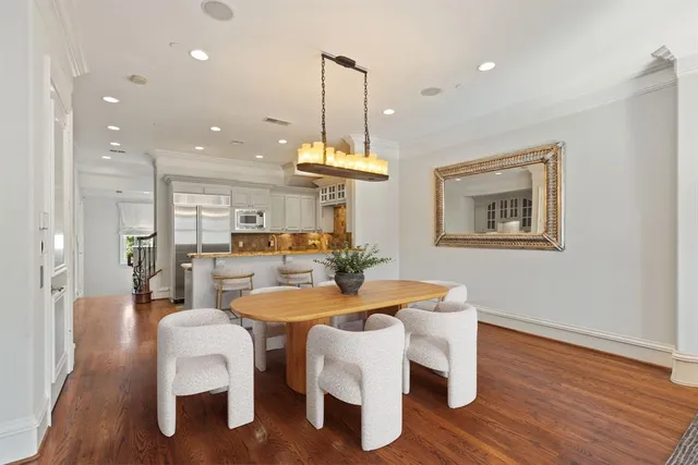 a dining room with furniture a chandelier and wooden floor
