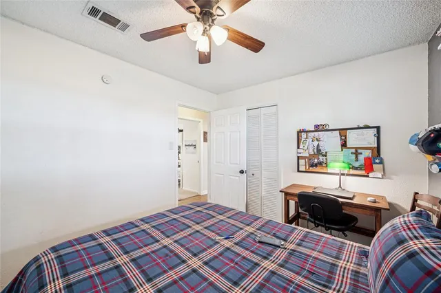 a bedroom with a bed and a chandelier fan