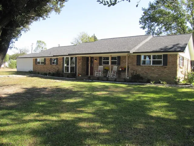 a front view of a house with a yard and trees