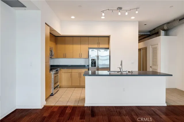 a large kitchen with stainless steel appliances granite countertop a sink and dishwasher with wooden floor