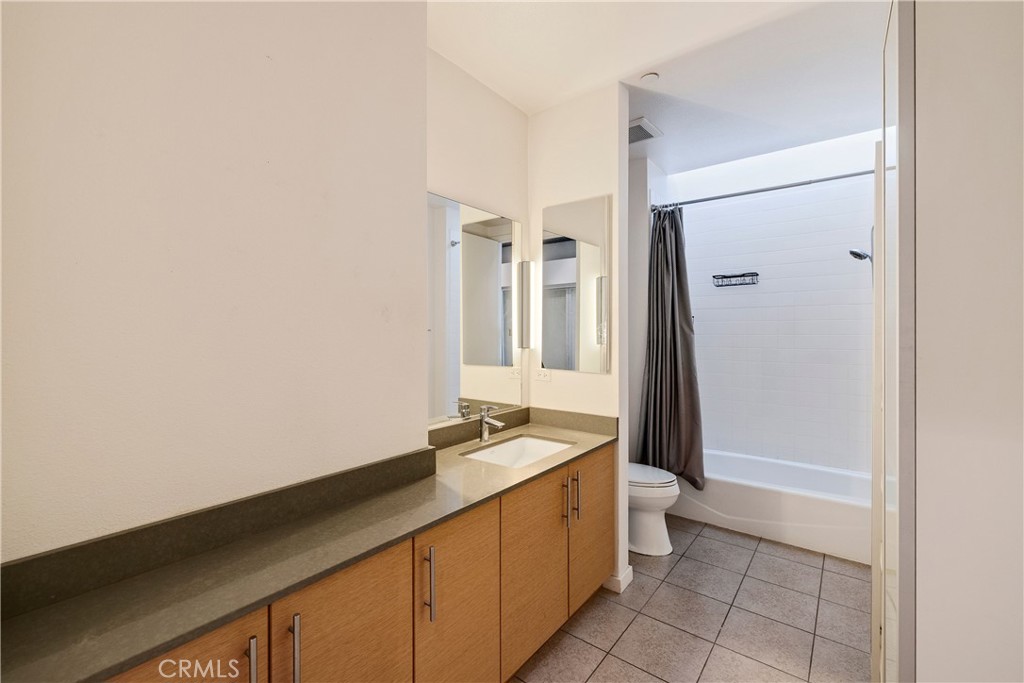 133 The Promenade North, Unit 426 Long Beach, CA 90802 - Photo 26 of 57 a spacious bathroom with a granite countertop sink and a mirror