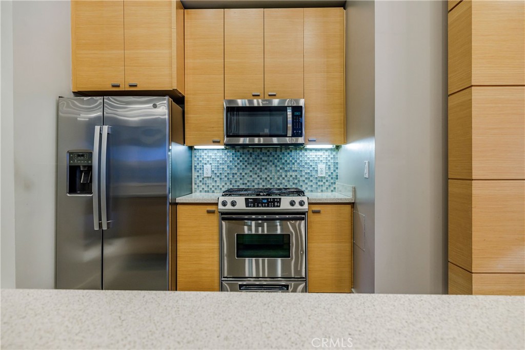 133 The Promenade North, Unit 426 Long Beach, CA 90802 - Photo 39 of 57 a kitchen with stainless steel appliances granite countertop a refrigerator and a stove