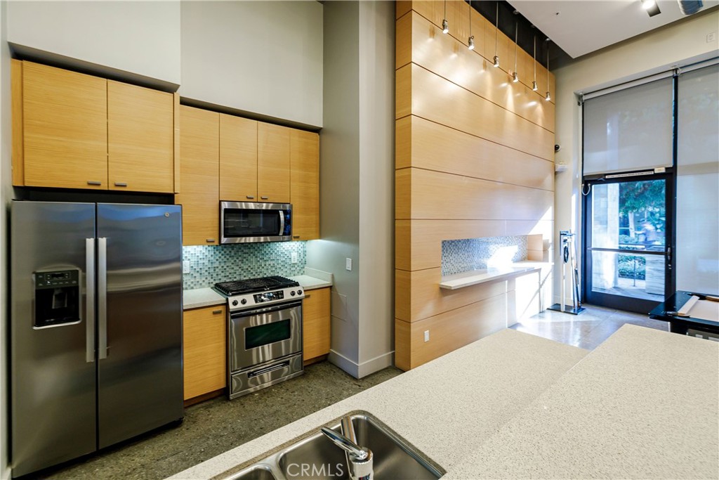 133 The Promenade North, Unit 426 Long Beach, CA 90802 - Photo 40 of 57 a kitchen with a stove a refrigerator and a view of living room