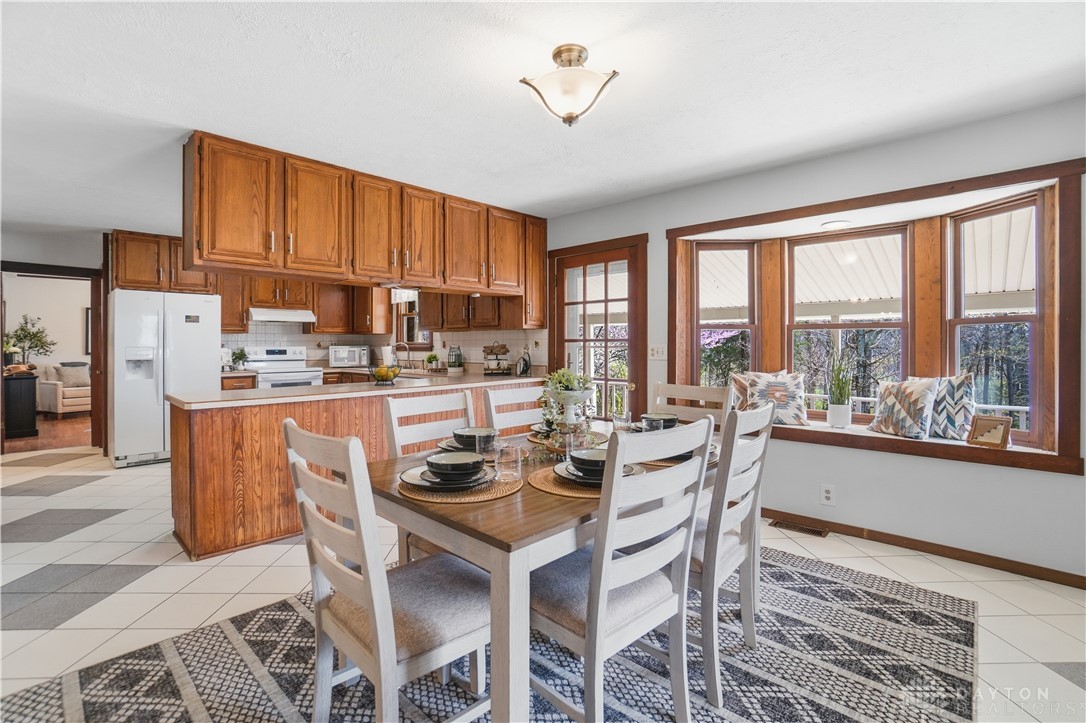 7553 Coffin Station Road Springfield, OH 45502 - Photo 43 of 95 This spacious kitchen and dining area offers ample cabinetry and natural light through its large bay window.