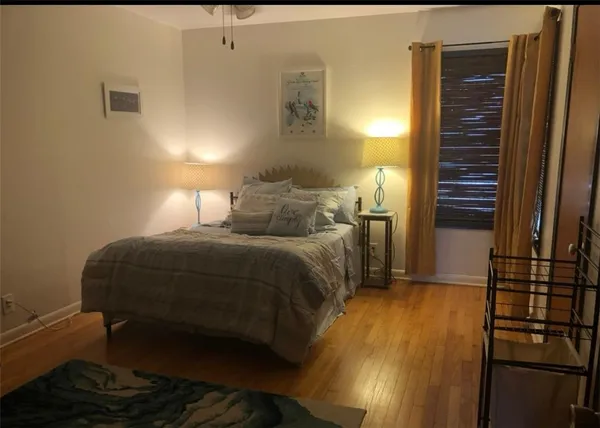 a bedroom with a bed and a lamp with the dresser