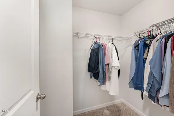 a view of walk in closet with clothes