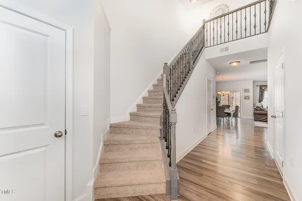 a view of staircase with lots of frames on wall and wooden floor