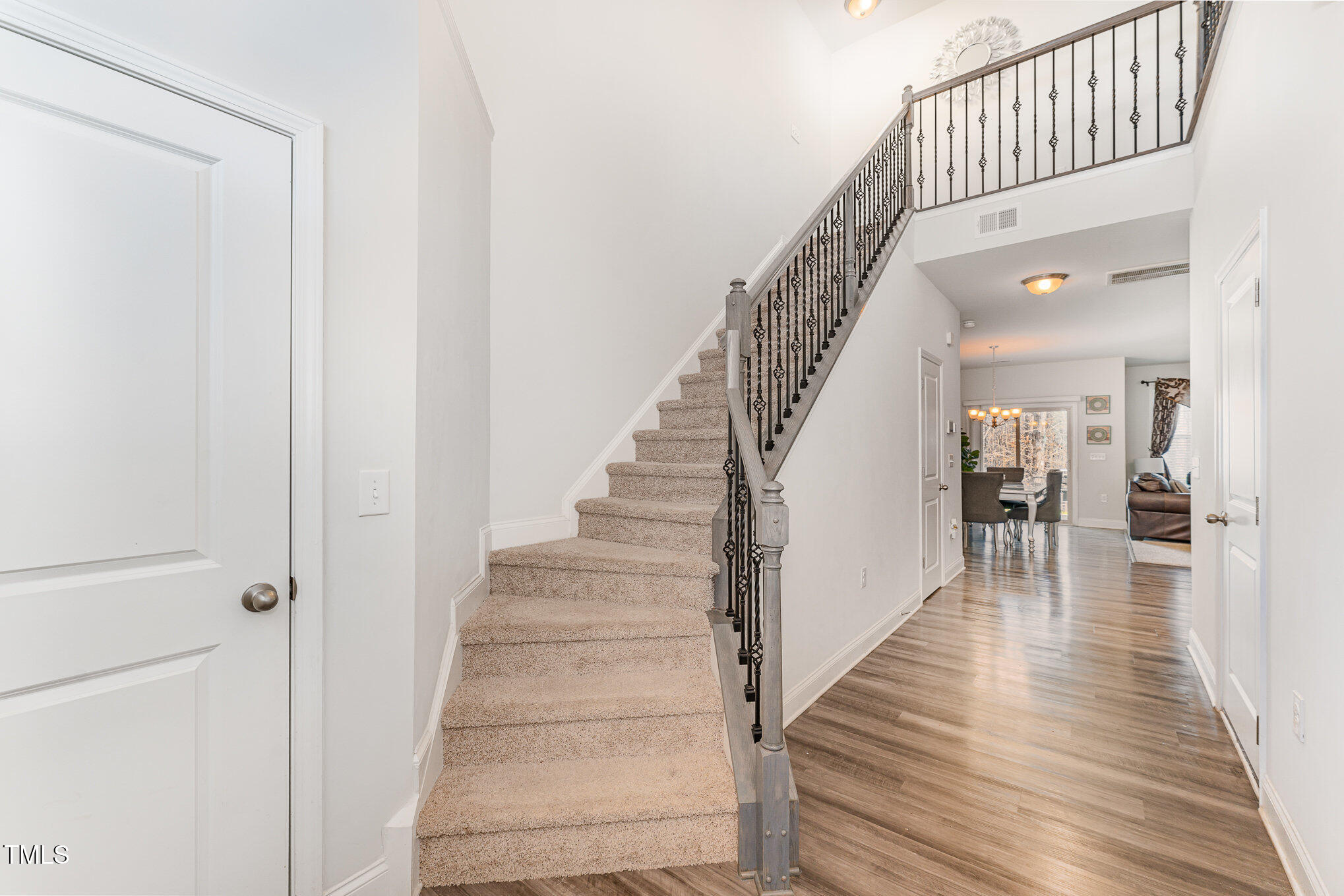 1101 Longitude Drive Durham, NC 27713 - Photo 3 of 26 a view of staircase with lots of frames on wall and wooden floor