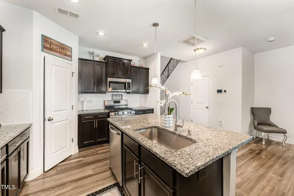a kitchen with stainless steel appliances granite countertop a sink stove and refrigerator