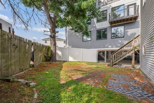 a view of an house with backyard and trees