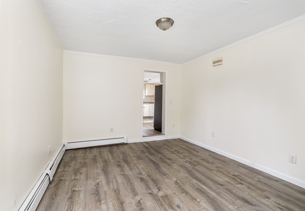 111 Washington Street, Unit 2 Somerville, MA 02145 - Photo 3 of 14 an empty room with wooden floor and windows