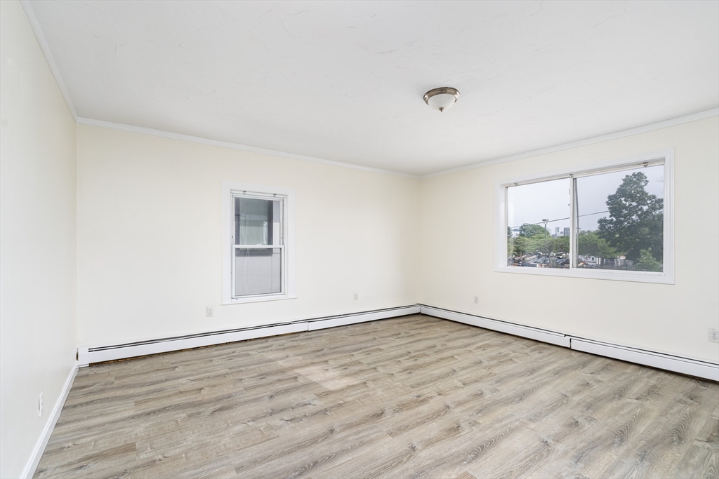 111 Washington Street, Unit 2 Somerville, MA 02145 - Photo 6 of 14 wooden floor in an empty room with a window