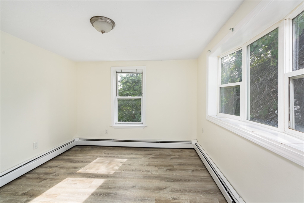 111 Washington Street, Unit 2 Somerville, MA 02145 - Photo 7 of 14 an empty room with wooden floor and windows