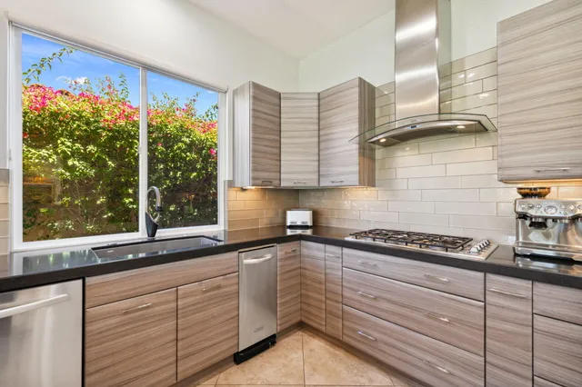 a kitchen with stainless steel appliances kitchen island granite countertop a stove a sink and a refrigerator