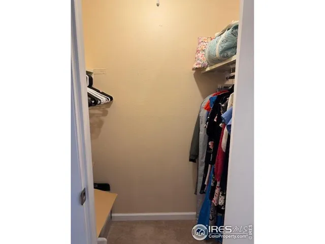 a view of walk in closet with clothes and shoes
