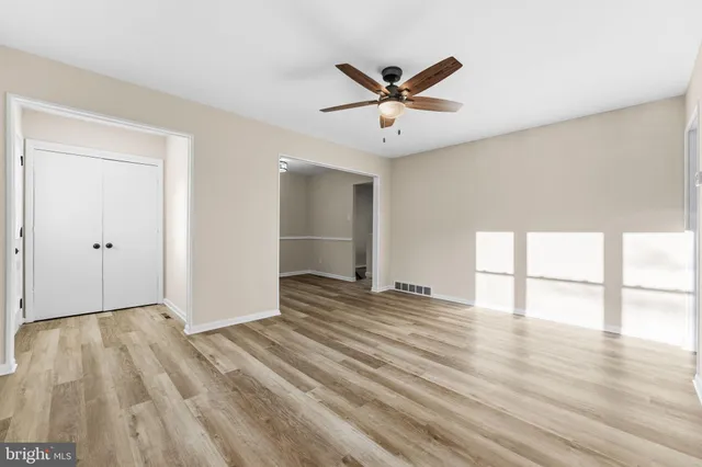 a view of an empty room and window with wooden floor