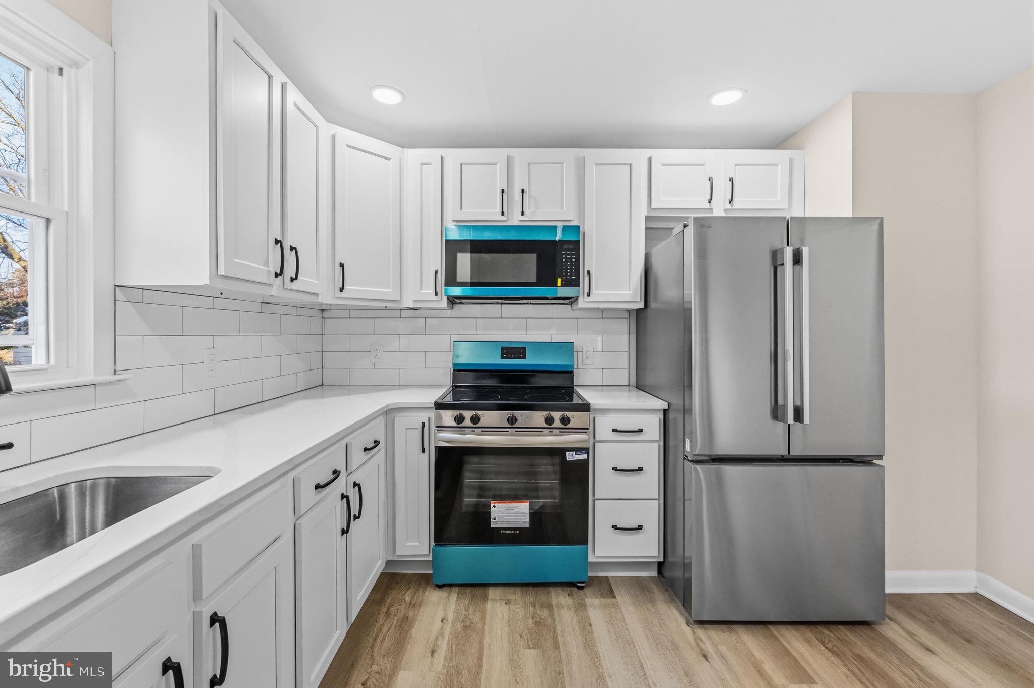 819 Old Harmony Road Newark, DE 19711 - Photo 4 of 39 a kitchen with cabinets stainless steel appliances and wooden floor