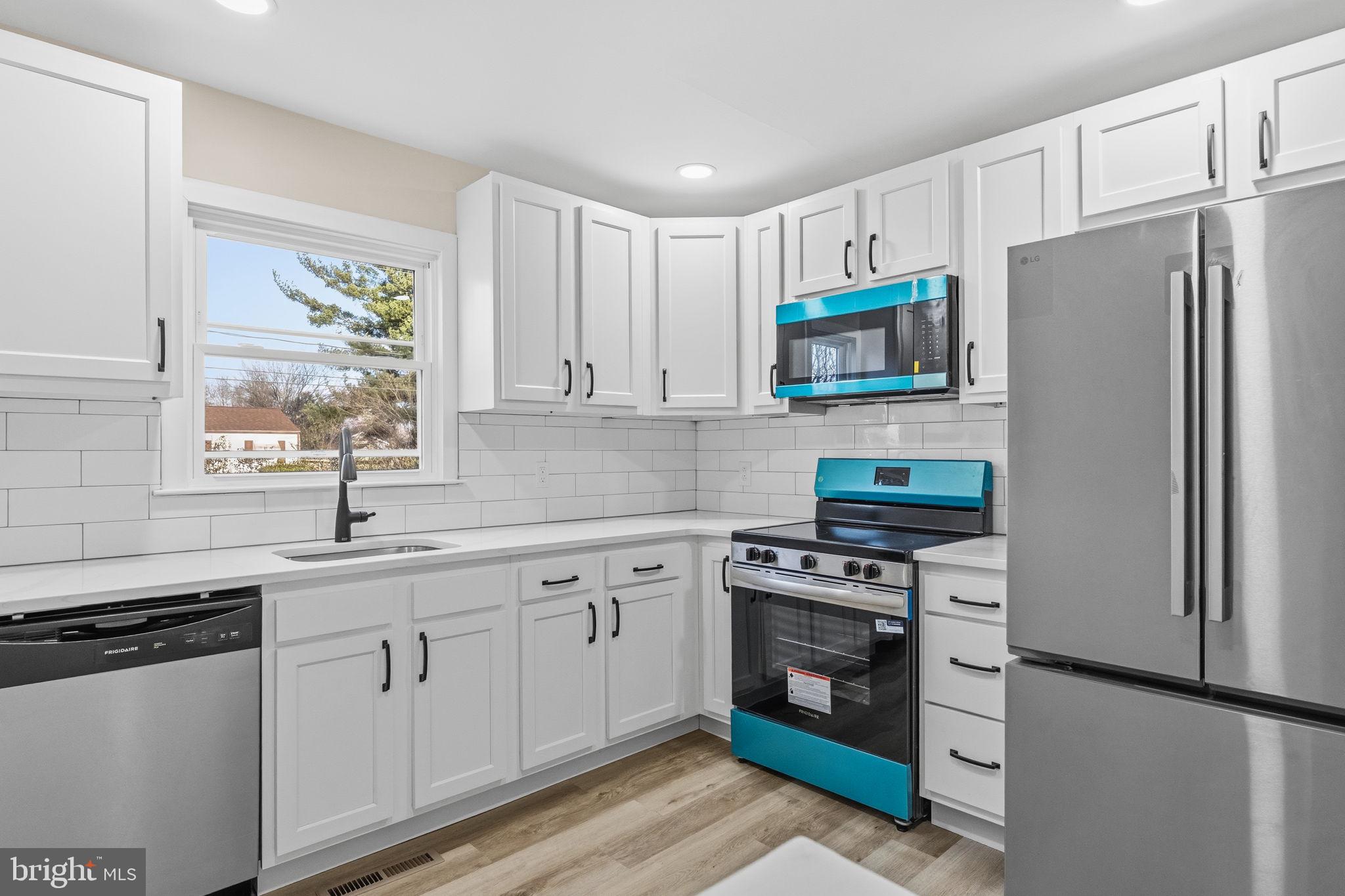 819 Old Harmony Road Newark, DE 19711 - Photo 5 of 39 a kitchen with white cabinets white stainless steel appliances and sink