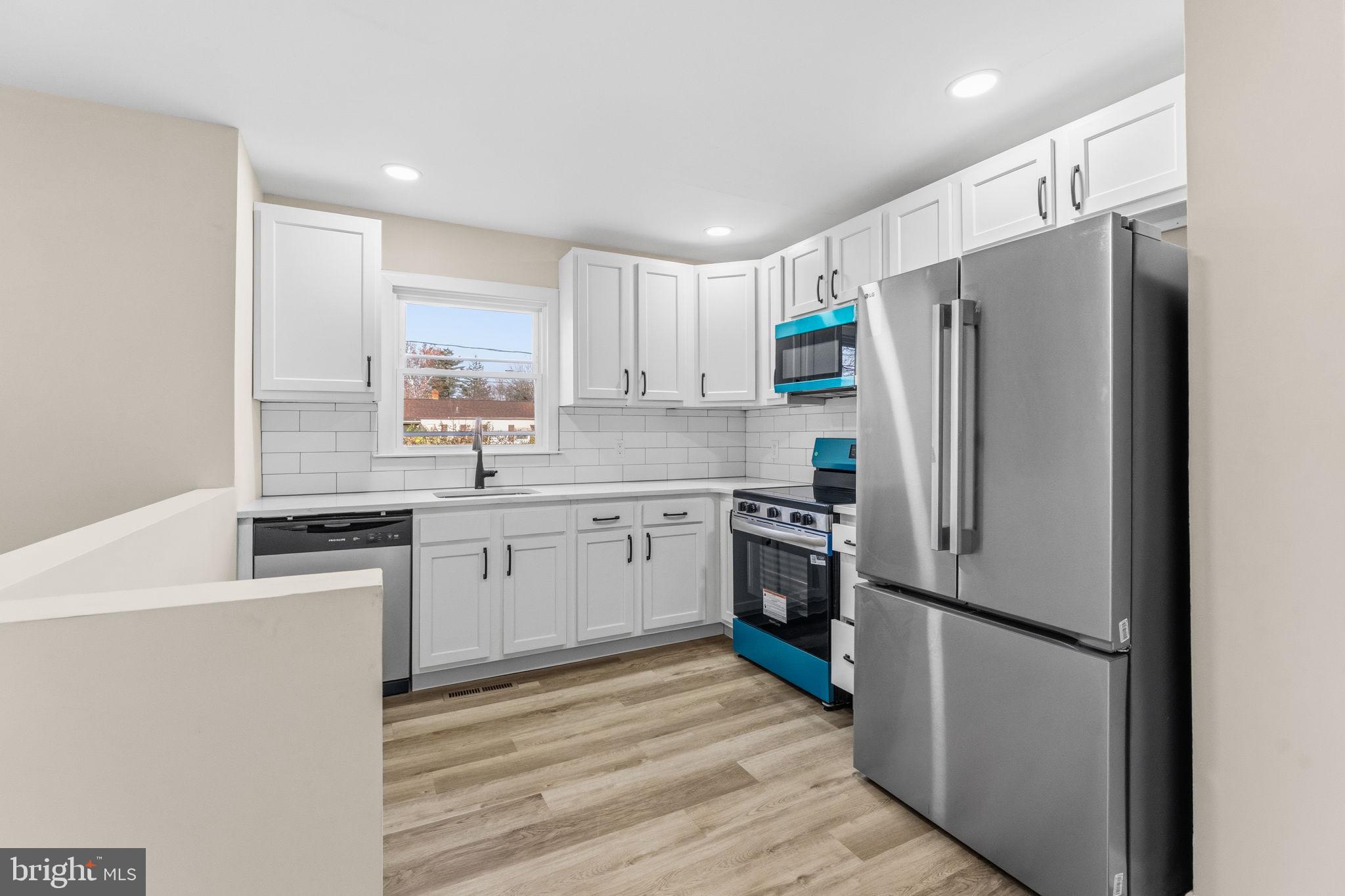 819 Old Harmony Road Newark, DE 19711 - Photo 6 of 39 a kitchen with a refrigerator stainless steel appliances wooden floor and cabinets