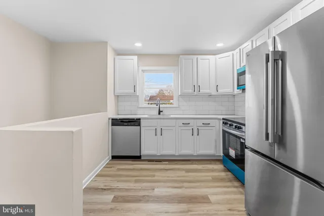 a kitchen with a sink cabinets stainless steel appliances and a window