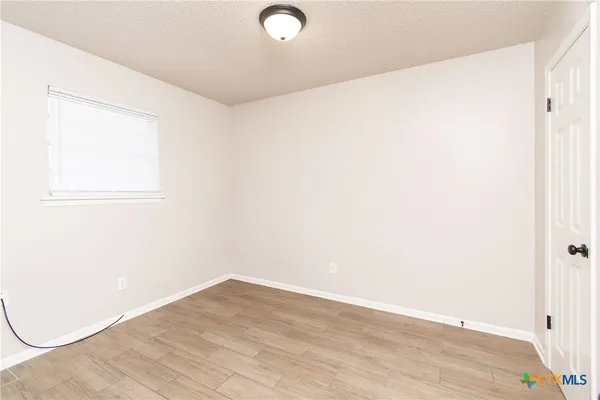 a view of a room with wooden floor and white walls