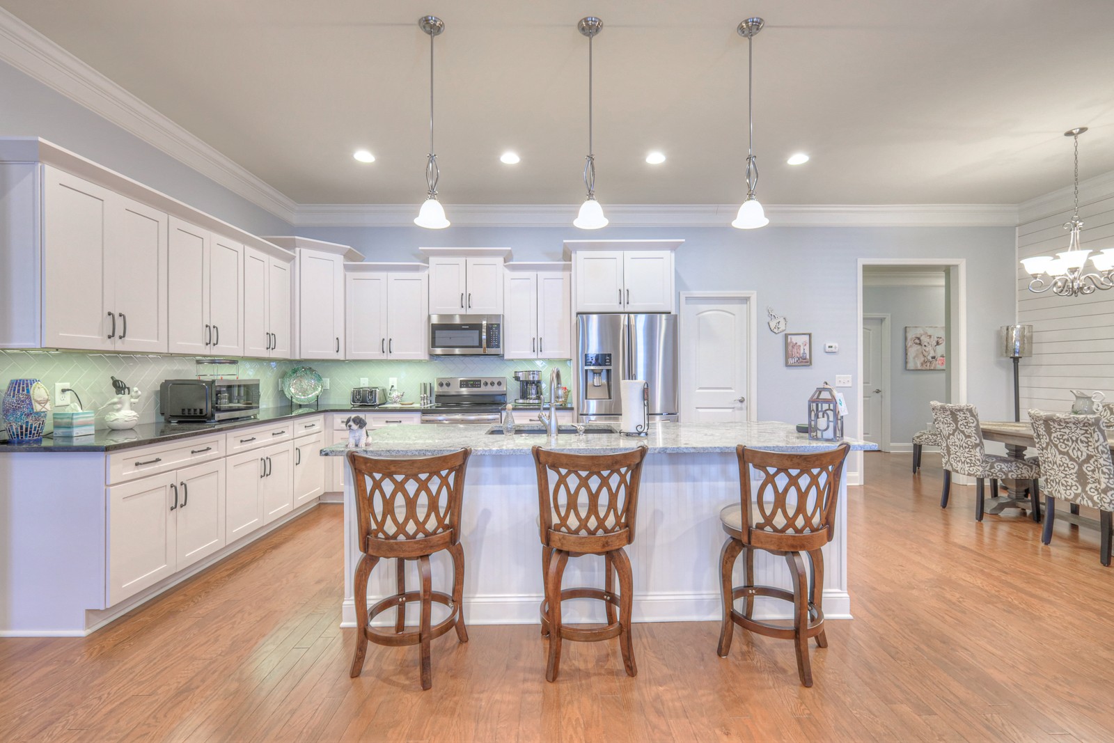 2252 Stonecenter Lane Murfreesboro, TN 37128 - Photo 11 of 36 a kitchen with stainless steel appliances granite countertop a dining table chairs stove and white cabinets
