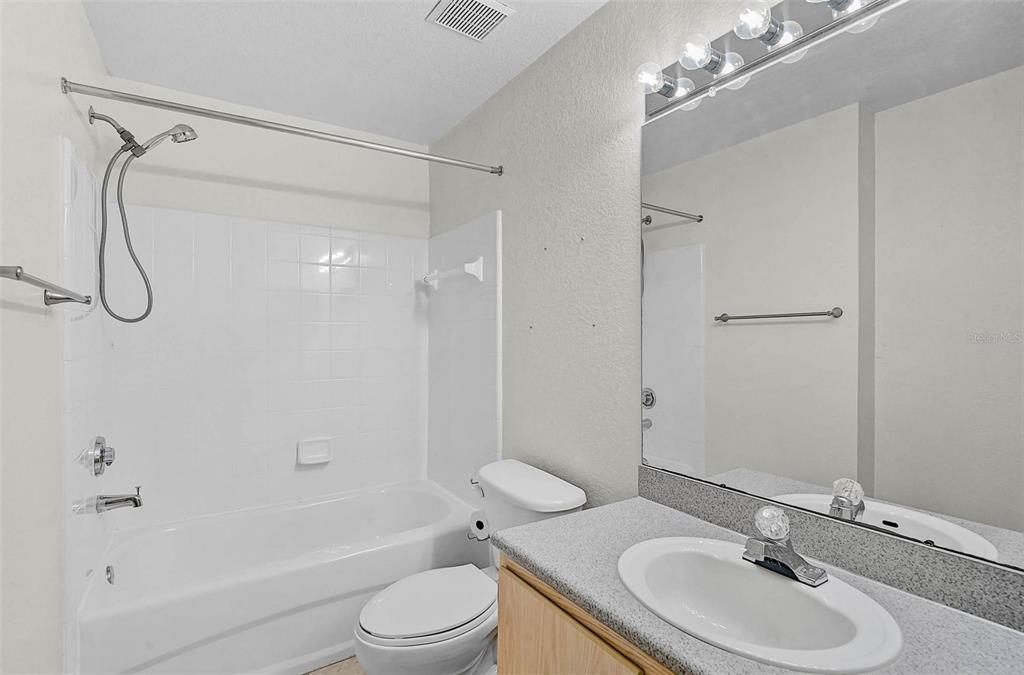 8827 Manor Loop, Unit 204 Lakewood Ranch, FL 34202 - Photo 19 of 31 a bathroom with a sink a toilet and a shower